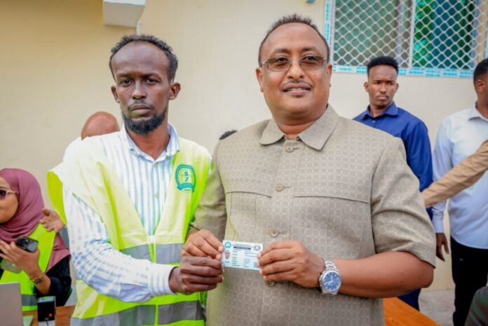 Mayor of Mogadishu receives voter card ahead of local elections, calls for public engagement and security cooperation.